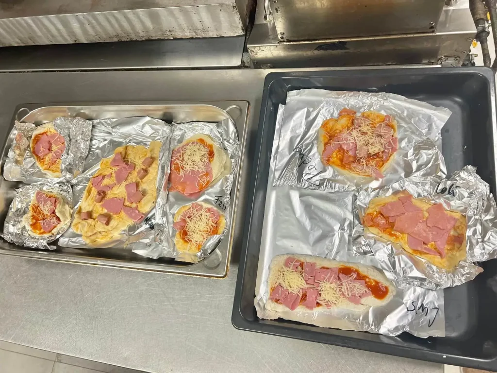 Piizas antes de hornear. Curso de cocina en la residencia de mayores